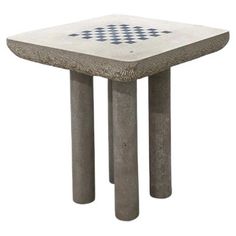 a cement table with blue and white designs on the top, sitting in front of a white background