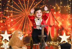 a little boy sitting on top of a chair next to a lion and circus tent