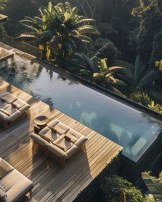 an outdoor pool with lounge chairs next to it and trees in the backround