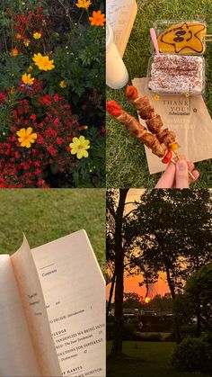 an open book sitting on top of a lush green field next to flowers and trees