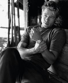 a man sitting on top of a wooden bench