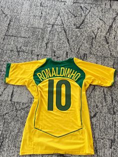 a yellow and green soccer jersey laying on the ground with it's number 10