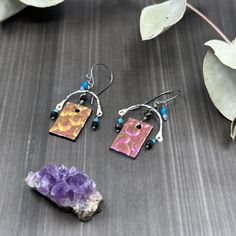 These earrings are so fun! The 13x20.5mm glass charms are super glowy and shift between pink, purple, and gold. I paired them with my hand forged sterling silver curved bars, 3.5mm faceted elongated black spinel, 3mm faceted apatite, 2mm faceted apatite, and 2mm faceted tanzanite.These earrings are sterling silver with 20 gauge earwires.Each earring is just under 2” long and weighs 2.4 grams. Everyday Soldered Dangle Earrings, Nickel Free Pink Copper Earrings, Nickel-free Pink Copper Earrings, Everyday Silver Copper Earrings, Artsy Nickel-free Sterling Silver Earrings, Hand Forged Artsy Earrings For Gifts, Artsy Hand Forged Earrings For Gift, Artsy Hand Forged Earrings As Gift, Artsy Nickel-free Everyday Jewelry