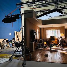 an empty room with many lights and equipment on the floor, including a camera set up in front of a window