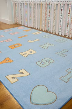 a blue rug with letters and hearts on it