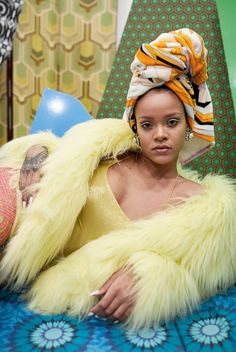 a woman laying on top of a bed wearing a yellow fur coat and head scarf