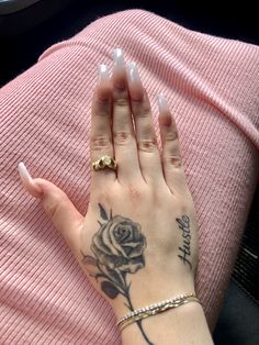 a woman's hand with a rose tattoo on it