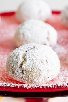 several powdered sugar balls on a red plate