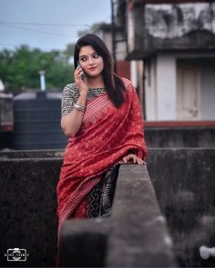 a woman in a red sari talking on her cell phone