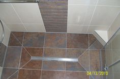 a bathroom with tiled floor and shower stall