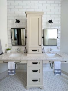 a white bathroom with two sinks and mirrors