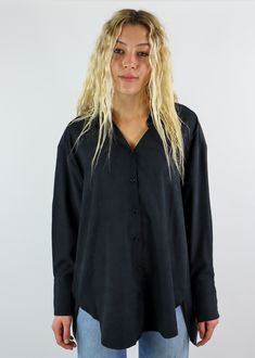 This oversized black button down is a closet essential! It features an oversized fit with button down closures in the front. There are so many ways you can style this staple piece! Pair this top with a pair of jeans and wear it half tucked in for a casual but put together look or throw a sweater over it a pull the collar through for more of a business casual look. Model Info Meet Zoe! Here she is wearing a size small. Hips: 35” | Waist: 25” | Bust: 32” | Height: 5’7” The Details Button Down Fron Oversized Tops With Snap Buttons For Everyday, Versatile Black Button-up Shirt, Versatile Black Fall Shirt, Oversized Black Button-up Shirt, Oversized Shirt With Button Closure For Everyday, Oversized Black Tops With Buttons, Edgy Button-up Top For Fall, Oversized Black Top With Buttons, Edgy Button-up Fall Tops