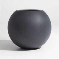 a black vase sitting on top of a white table