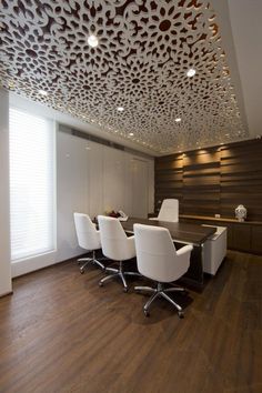 an office with wooden floors and white chairs