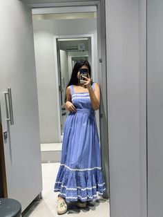 a woman in a blue dress taking a selfie