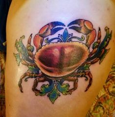 a crab tattoo on the side of a woman's thigh