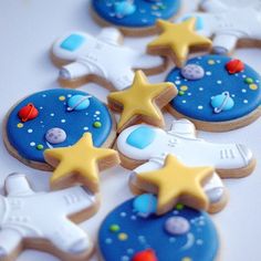 some cookies that are on a table with stars and space related decorations in the middle