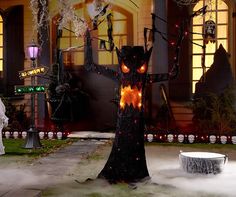 a halloween tree with lights and decorations in front of a building