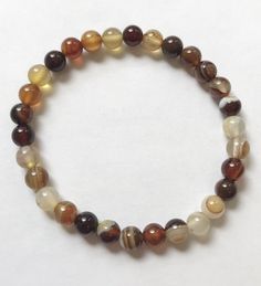 Brown Striped Agate is a beautiful crystal great for grounding and protection. It is a healing crystal and vibrates at a lower energy allowing the wearer to calm down and soothe their anger, creating a sense of safety and security, lessening anxiety, and protecting the aura from negative vibrations. Product Description:6mm brown striped agate beads Global site tag (gtag.js) - Google Ads: 645572217 window.dataLayer = window.dataLayer || []; function gtag(){dataLayer.push(arguments);} gtag('js', n Brown Beaded Bracelets, Brown Crystals, Bracelets Beads, Capricorn Moon, Earthy Jewelry, Brown Accessories, Moon Bracelet, Brown Bracelet, Brown Jewelry