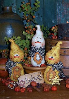 three little figurines sitting on top of a table next to some pumpkins