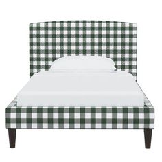 a bed with a green and white checkered headboard on it's side