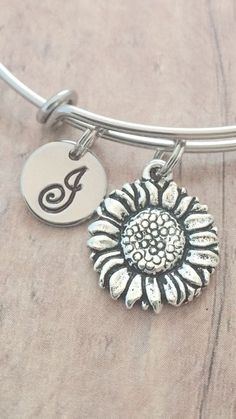 "This listing is for a hand stamped initial bangle featuring a 7/10\" x 3/5\" pewter sunflower charm & 2/5\" stainless steel initial pendant. The stainless steel bangle measures 65mm (2.5\") in diameter and fits most adult women's wrists. All items are lead & nickel free. Please message me with any questions, thank you! Add an initial to any item: https://www.etsy.com/listing/170461597/add-an-initial?ref=shop_home_active&ga_search_query=Add Add a birthstone to any item: https://www.e Sunflower Bracelet, Sunflower Charm, Sunflower Jewelry, Tyler Tx, Sunflower Pendant, Jewelry Summer, Stainless Steel Bangles, Garden Jewelry, Initial Pendant