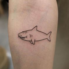 a small shark tattoo on the right thigh, with an outline of a shark in it's mouth