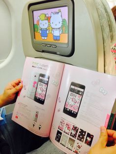 someone is reading a hello kitty book on an airplane