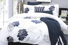 a bed with blue and white comforters in a room