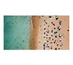 an aerial view of people on the beach and in the water, with umbrellas