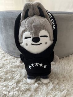 a small stuffed animal wearing a black hoodie and stars on it's chest