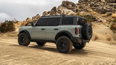 an off - road vehicle is driving through the desert