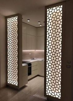 an open kitchen with white cabinets and decorative screens on the walls, along with wooden flooring