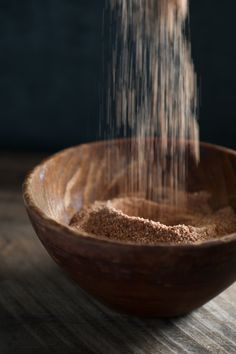 a wooden bowl filled with sand on top of a table