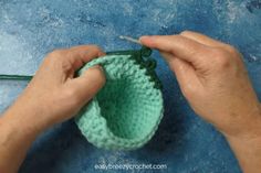 someone is crocheting the bottom part of a small green object with yarn on it