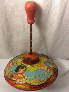 an old fashioned hand painted box with a wooden stick sticking out of it's top