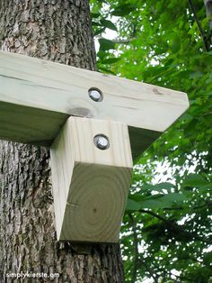 a wooden bird house attached to a tree