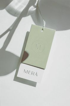 a tag with the word mera hanging from it's side on a white surface