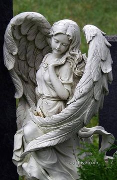 an angel statue with the words dear angels written in white on it, next to a grave