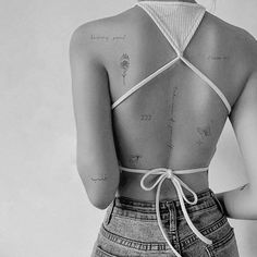 the back of a woman's body with tattoos on it