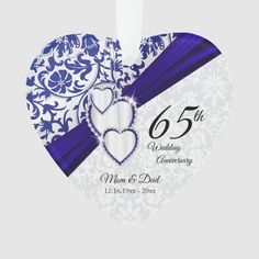 a white and blue heart shaped ornament with the number 65 on it's side