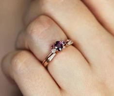 a woman's hand holding an engagement ring with two stones