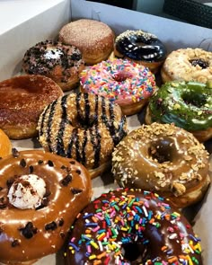 a box filled with lots of different flavored donuts