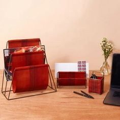 a desk with a laptop, pen holder and other items on top of the table