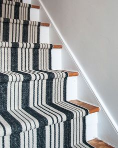 the stairs are painted black and white with vertical striped carpeting on each handrail