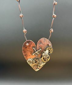 This one of a kind handmade hammered copper steampunk heart necklace hangs on a handmade solid copper balled end chain. This unique piece is wearable art. Whether your style is renaissance, steam punk, vintage, artsy or even sunken pirate treasure vibes this statement necklace is sure to get noticed.  In a world of cookie cutter, cheaply made and mass produced items we all need a piece in our collection that speaks to us and is made to stand the test of time. The heart pendant was a handmade, hand cut work of inspiration from start to finish. Sheet copper was transformed, hammered, filed, and stitched with copper wire in a cross your heart x. Lead free silver solder was used to accent and attach copper and brass tone gears, and texture was added, followed by patina to accent all the rustic Pink Heart Necklace, Copper Chain Necklace, Steampunk Heart, Copper Heart, Gifts For My Girlfriend, Steam Punk Jewelry, Special Necklace, Copper Art, Art Necklaces