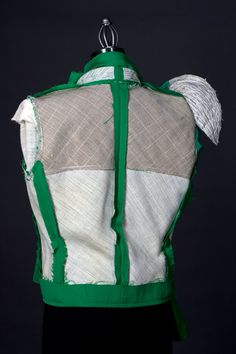 the back of a green and white jacket, with an attached tie on it's shoulder