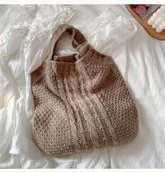 a knitted bag sitting on top of a bed