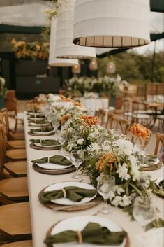 a long table with plates and flowers on it