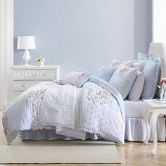 a bedroom with blue walls and white furniture